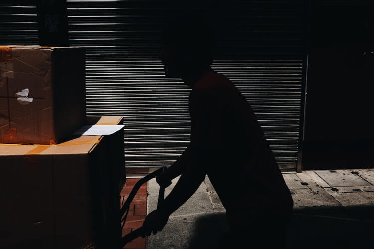 Image of a man moving cardboard boxes