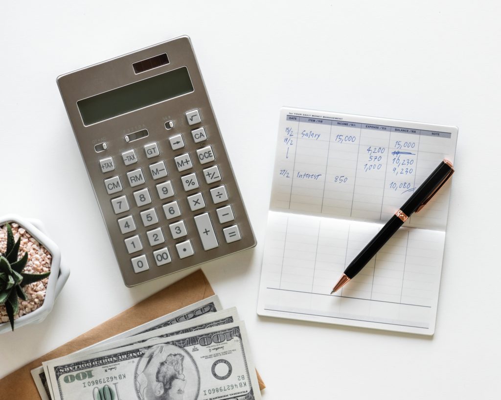 Calculating inventory cycle count with a calculator, pen, pencil, and money