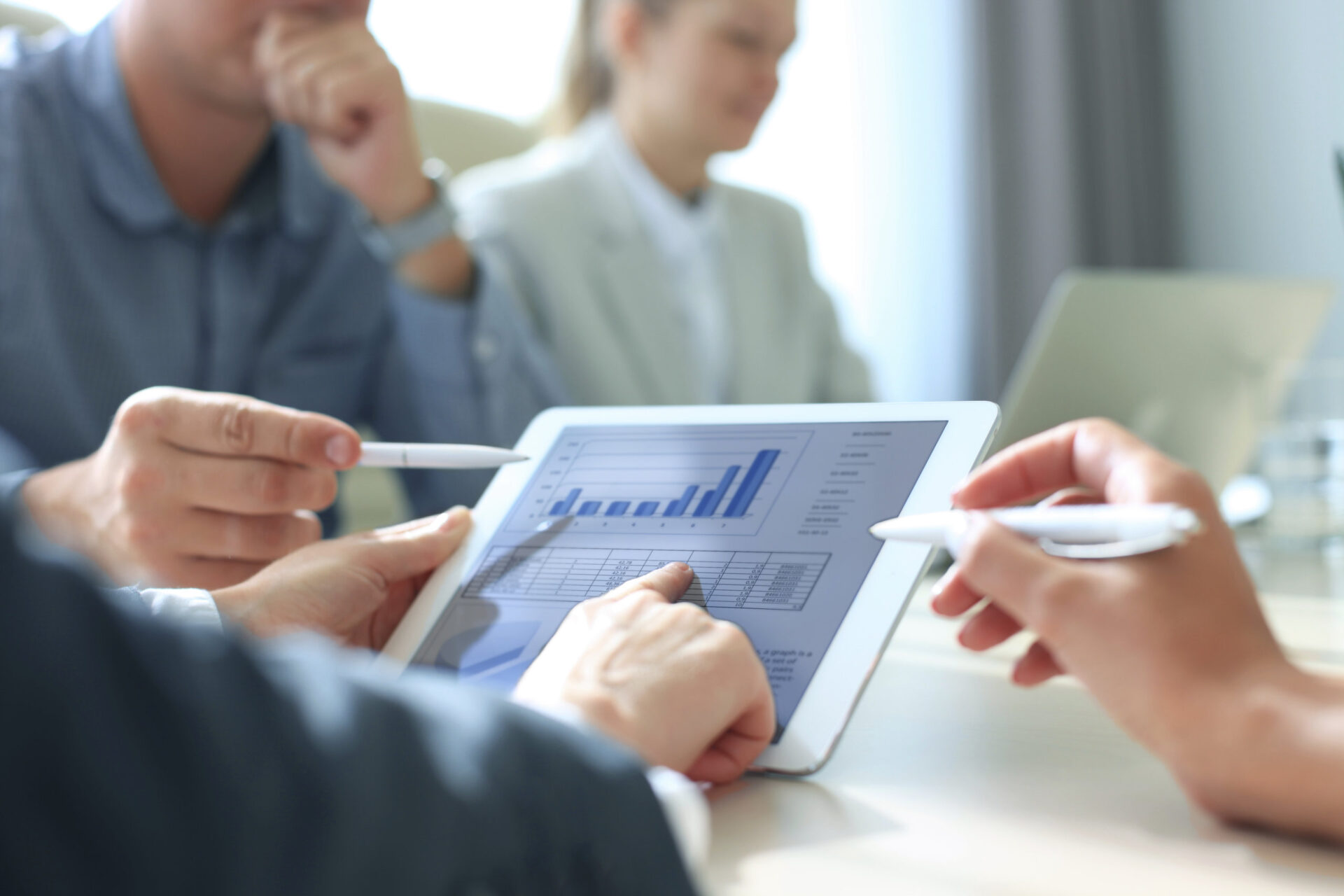 business coworkers reviewing charts on a tablet