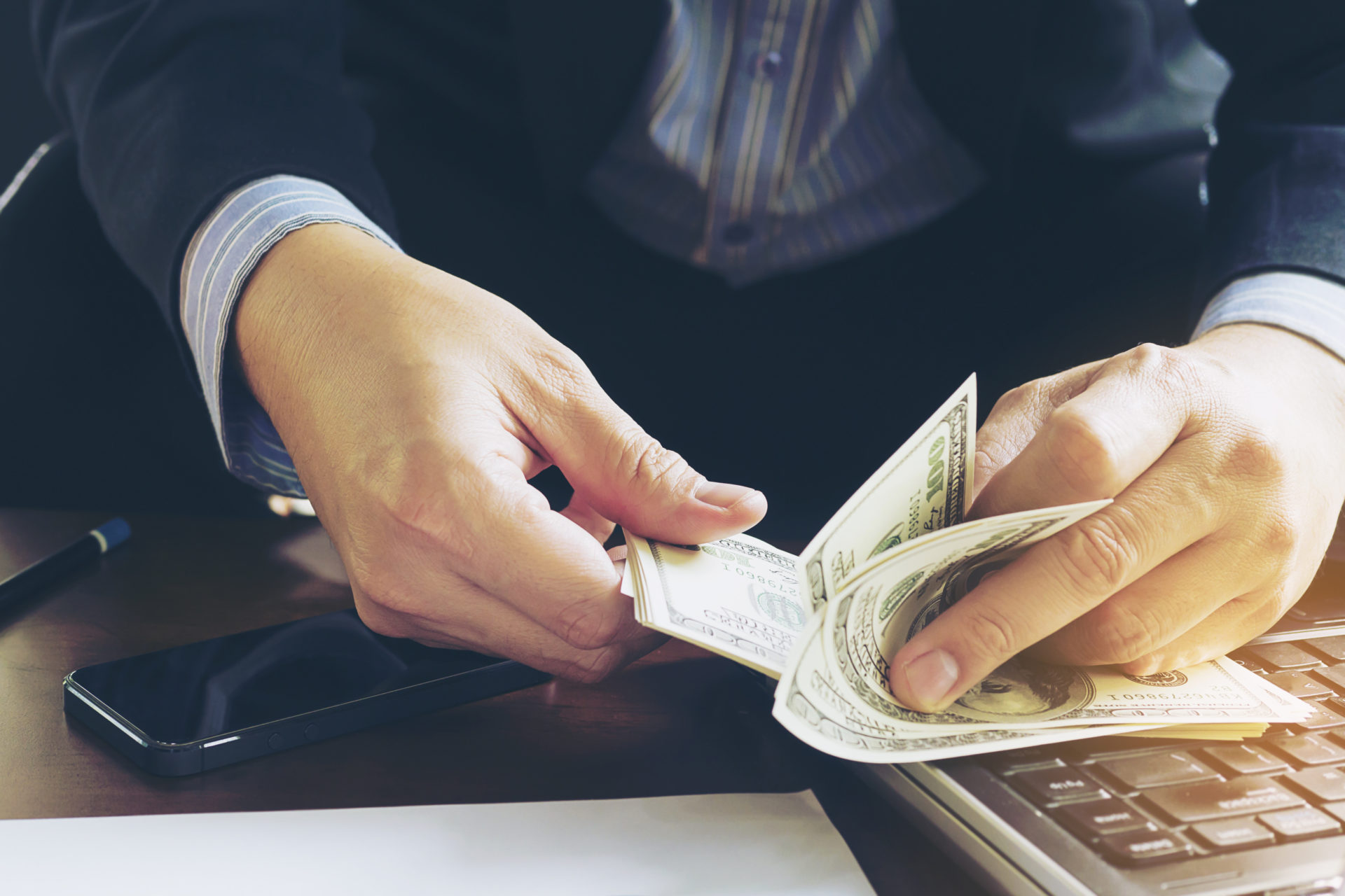 Business man counting dollar banknote - online business concept Earn passive income