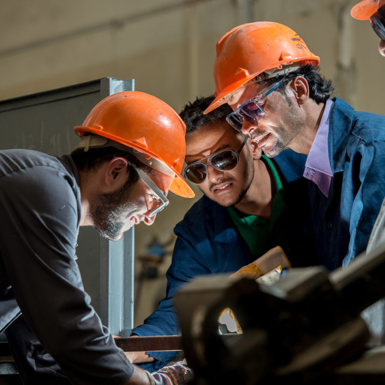 Workers in industrial factory welding